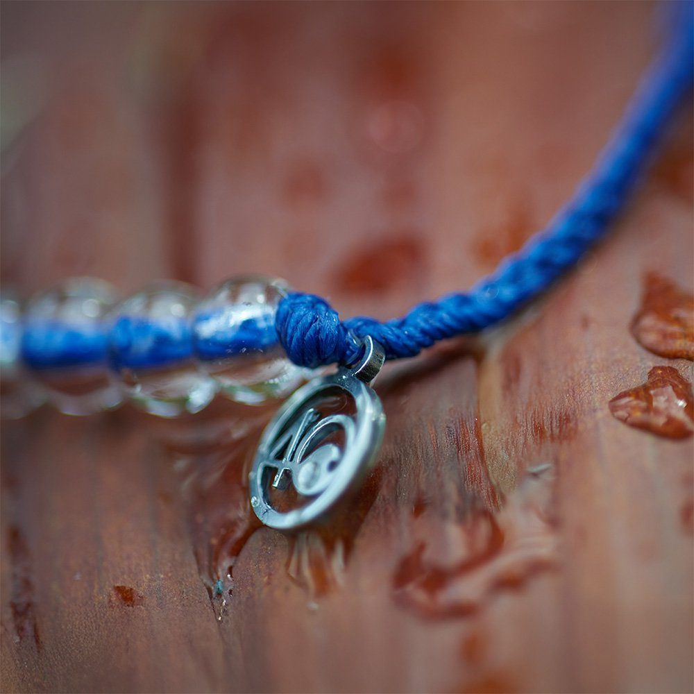 Close-up of the recycled stainless steel 4ocean charm and recycled plastic cord